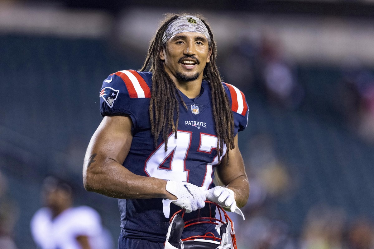 Jakob Johnson smiles while on the field for pre-game warmups